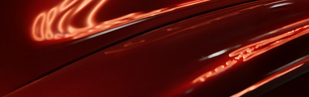 distorted neon reflected in a close up red car body